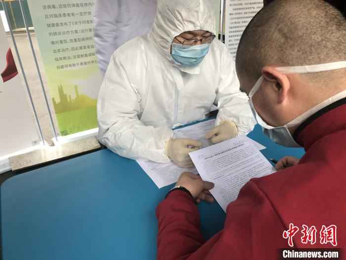 新冠肺炎恢复期血浆捐献者在阅读《成都市血液中心新冠肺炎康复者恢复期血浆捐献知情同意书》并签字确认。 吕杨 摄 四川第三位、第四位新冠肺炎康复者捐献恢复期血浆